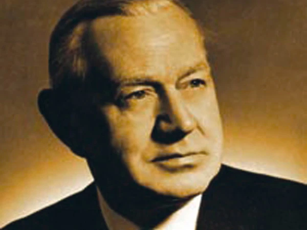 Sepia-toned portrait of a middle-aged man with short hair, shown in close-up and looking slightly to the side against a plain background.