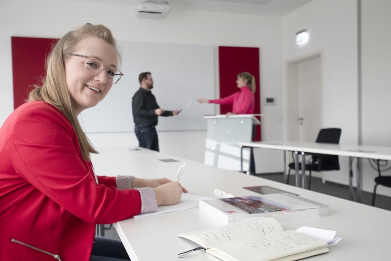 A training session in a modern office setting, focusing on compliance and guidelines, with notebooks and documents on the table