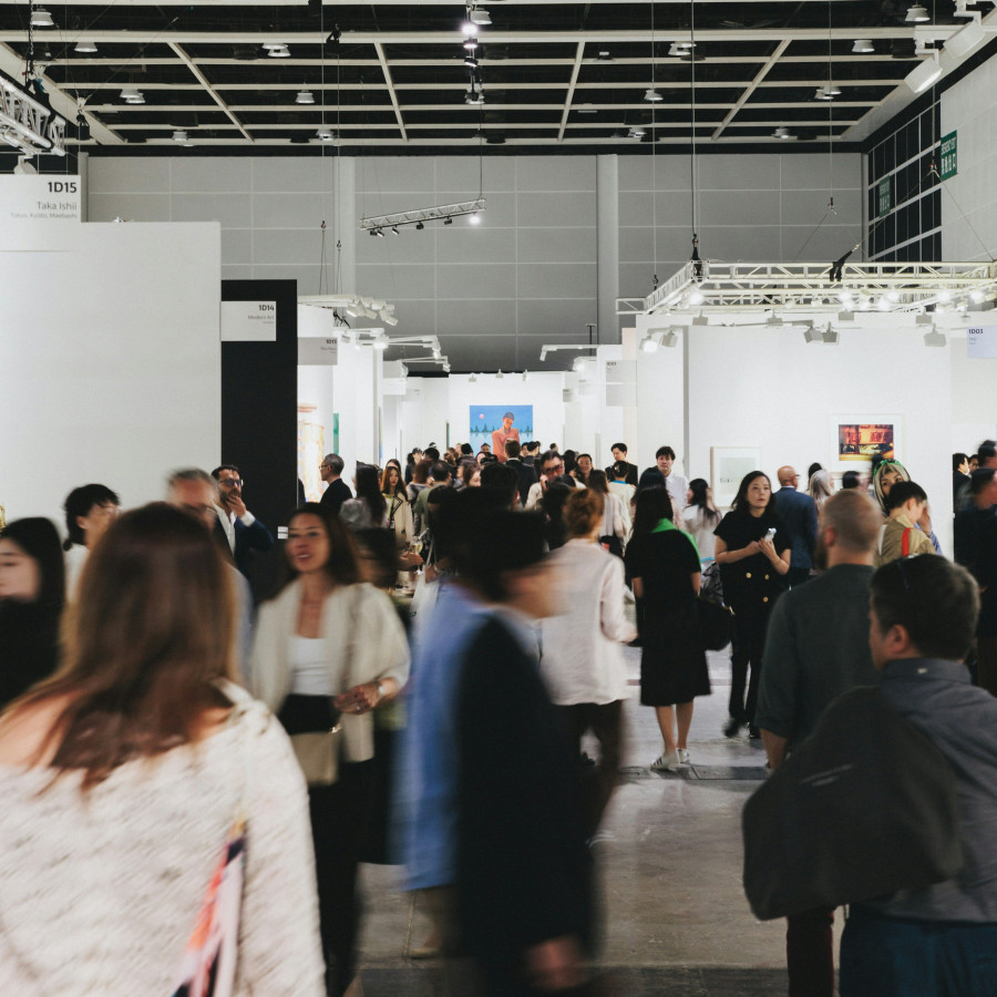 Hands of different people laid flat on a wooden table, representing unity and compliance